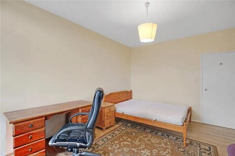 Spacious bedroom with a large desk and natural ...