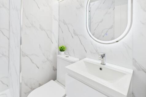 Modern bathroom with white marble walls, sleek ...