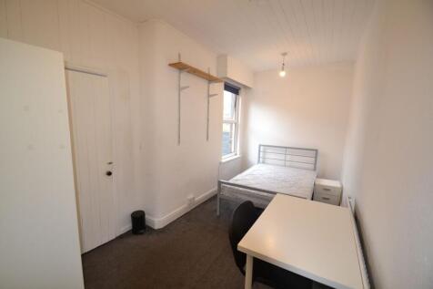 A compact single bedroom featuring a metal bed ...