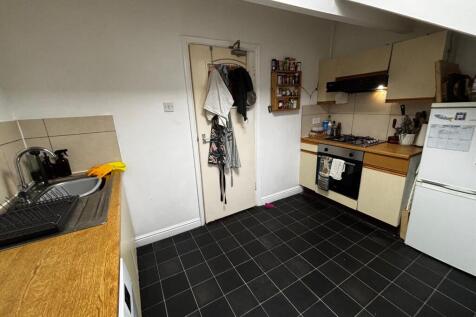 Compact fitted kitchen with tiled flooring, woo...