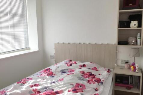 Bright bedroom with large window and built-in s...