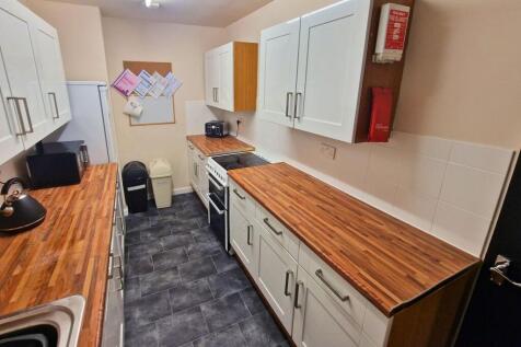 Long galley kitchen with matching wood-effect w...
