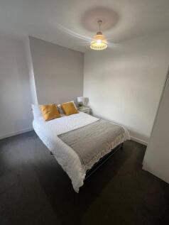A cozy and neatly arranged double bedroom featu...