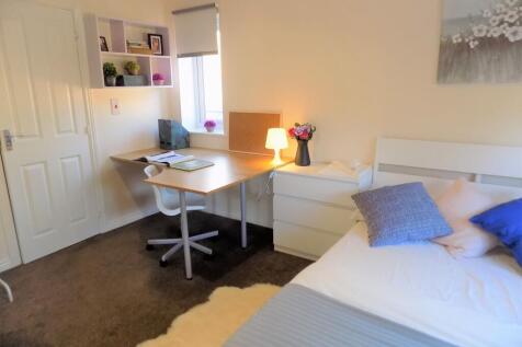 Bright, neatly presented bedroom with a built-i...