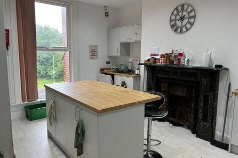 Bright kitchen with island and ornate fireplace...