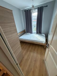 Neat, simply furnished bedroom with a wooden si...