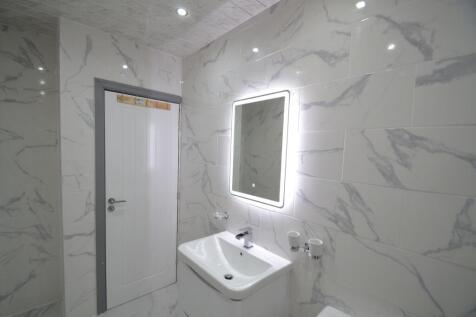 Modern and sleek bathroom with marble-effect ti...