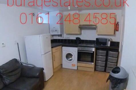 Bright open-plan kitchen area with light wood f...