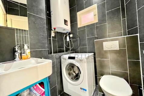 Compact laundry area with a washing machine, water