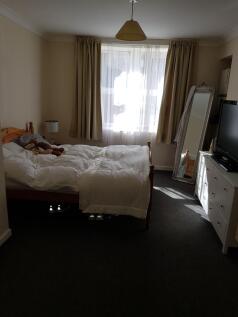 A cozy double bedroom featuring a neat wooden b...