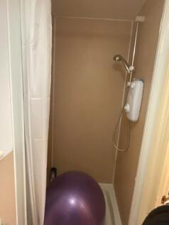 A compact bathroom featuring a shower, ideal fo...