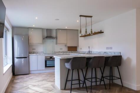 Contemporary open-plan kitchen with a marble-ef...