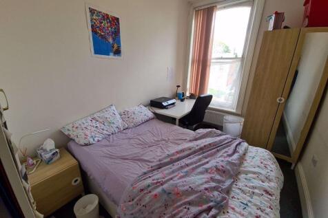 A cozy single bedroom featuring a comfortable b...