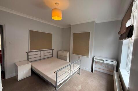 Bright double bedroom with a metal bed frame, n...