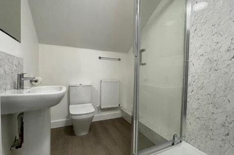 A clean and bright bathroom with a modern showe...