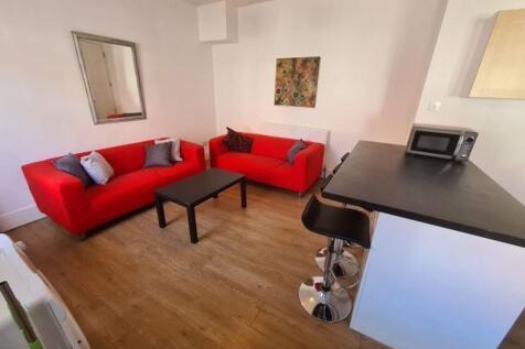 A cozy living room featuring bright red sofas, ...