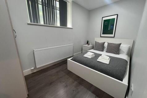 Neat, modern double bedroom with a white platfo...