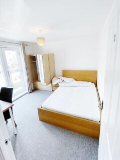 Bright, modern bedroom with a wooden double bed...