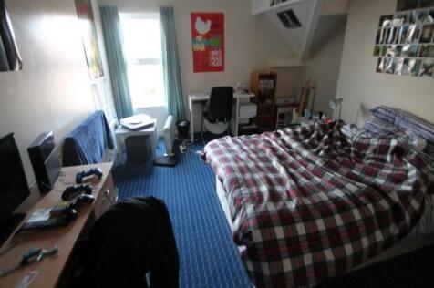 A cozy bedroom featuring a double bed with a ch...