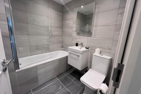 Modern tiled bathroom with a bathtub and glass ...