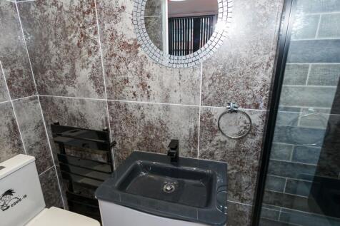 Modern tiled bathroom with a dark basin, contem...