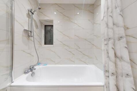 Bright, modern bathroom with a full-size bathtu...