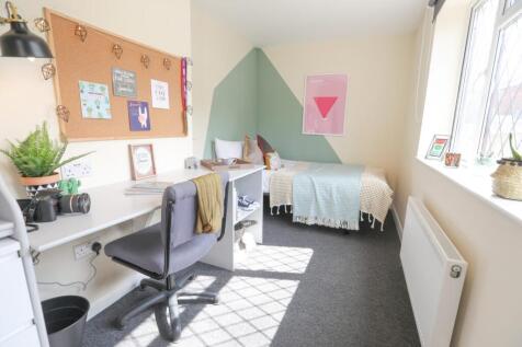 Bright and stylish bedroom featuring a comforta...