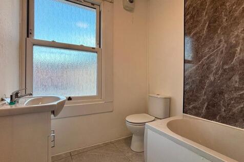 Bright bathroom featuring a full bathtub....