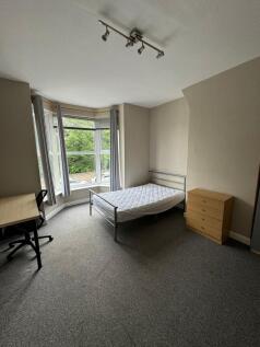 Bright double bedroom with a large bay window o...
