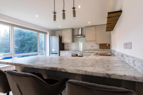 Bright modern kitchen with a large marble-effec...