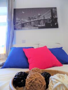 Bright, neatly styled double bedroom with color...