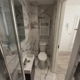 Compact, modern bathroom with marble-effect til...