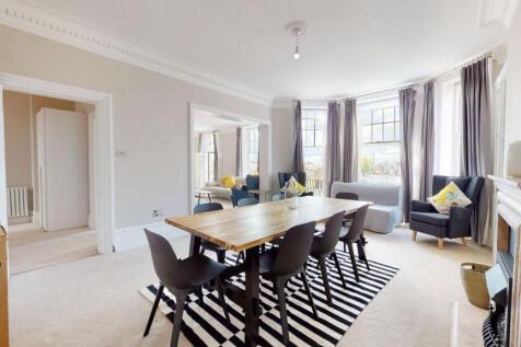 Bright and spacious living room featuring large...