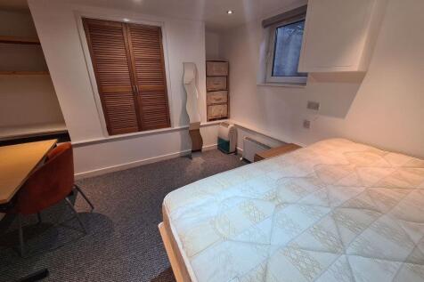 A well-maintained master bedroom featuring a do...