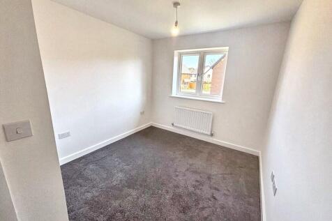 Bright, freshly painted bedroom with a central ...