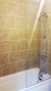 Modern tiled bath with integrated shower system...