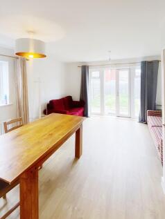 Bright, modern living space with wide patio doo...