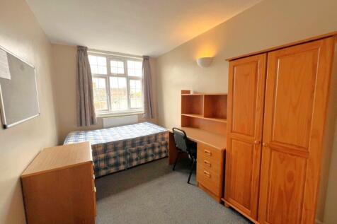 A cozy student bedroom featuring a single bed, ...