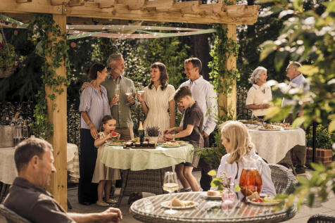 a group of people standing around a table with food on it
