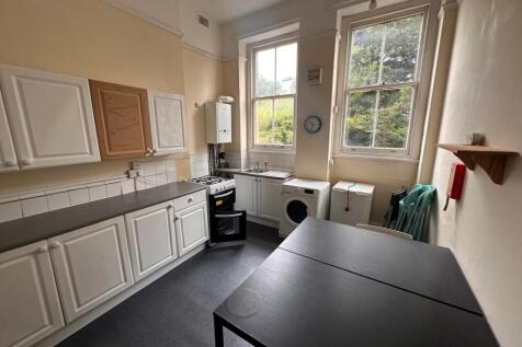 Bright kitchen with high sash windows overlooki...