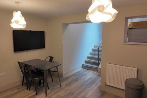 Bright, modern communal lounge with wall-mounte...