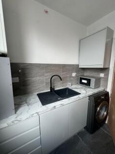 Contemporary kitchenette with marble-effect wor...