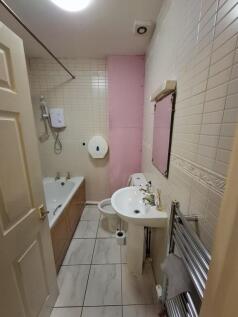 Bright bathroom with bathtub and heated rail...