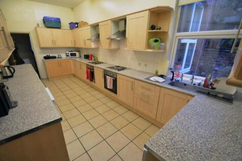 Long, modern communal kitchen with abundant bui...