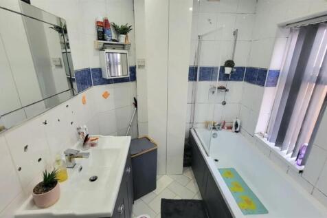 Bright, modern bathroom with a bathtub, separat...