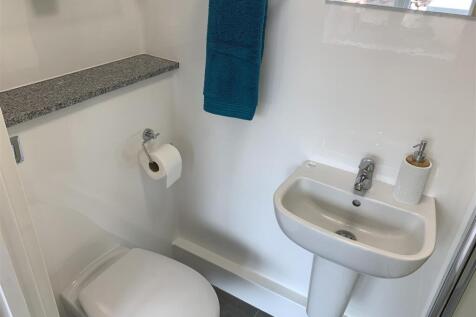 Compact modern WC with basin and shelving...