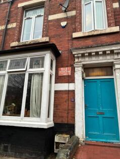 Charming red brick house with vibrant blue door...