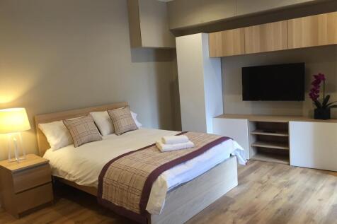 Elegant master bedroom with integrated smart TV...