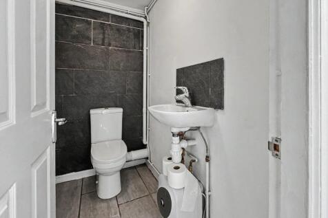 Modern single toilet with sleek dark feature wa...