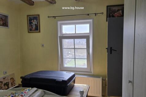 Bedroom window with radiator below and wardrobe visible beside the bed.